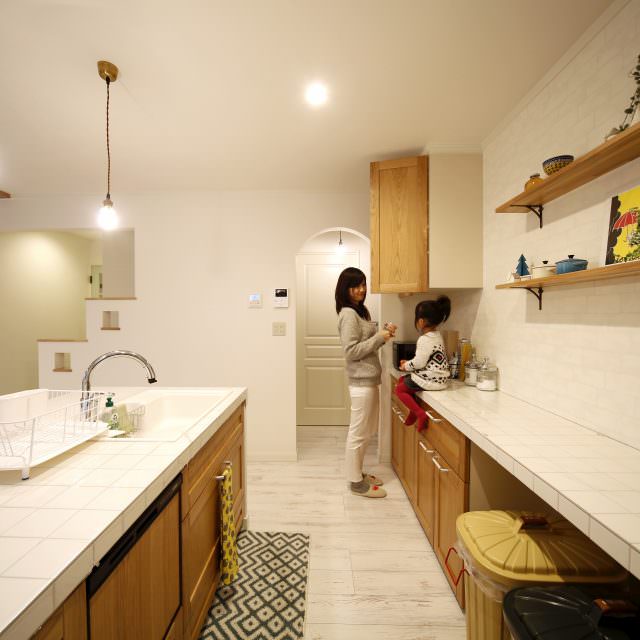 白いタイルと木の扉が合う清潔感あるキッチン