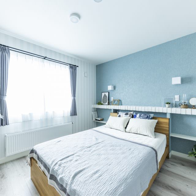 ブルーの壁紙と白ブリックの棚板のコントラストが北欧の雰囲気を演出する寝室
