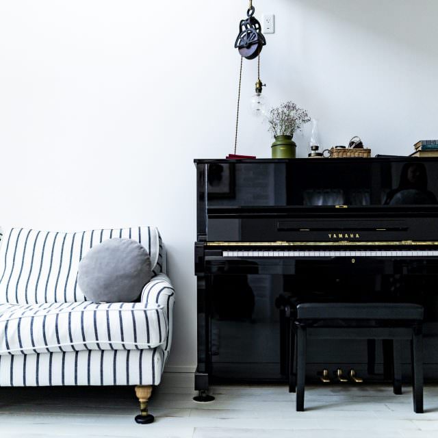 ピアノとボーダー柄のソファがあるフレンチシックな家