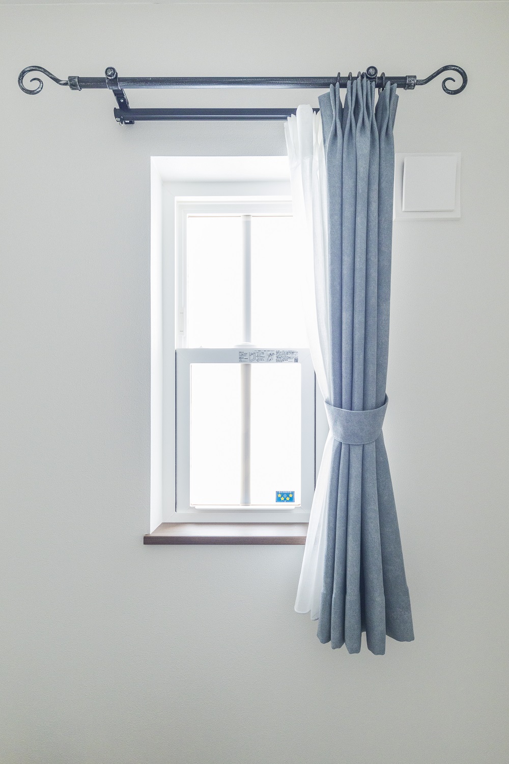 シンプルなブルーのカーテンも、格子窓やカーテンレールでおしゃれに演出。